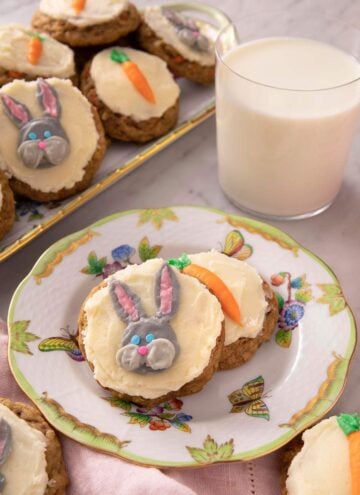 Carrot cake cookies on a plate with a glass of milk in the background