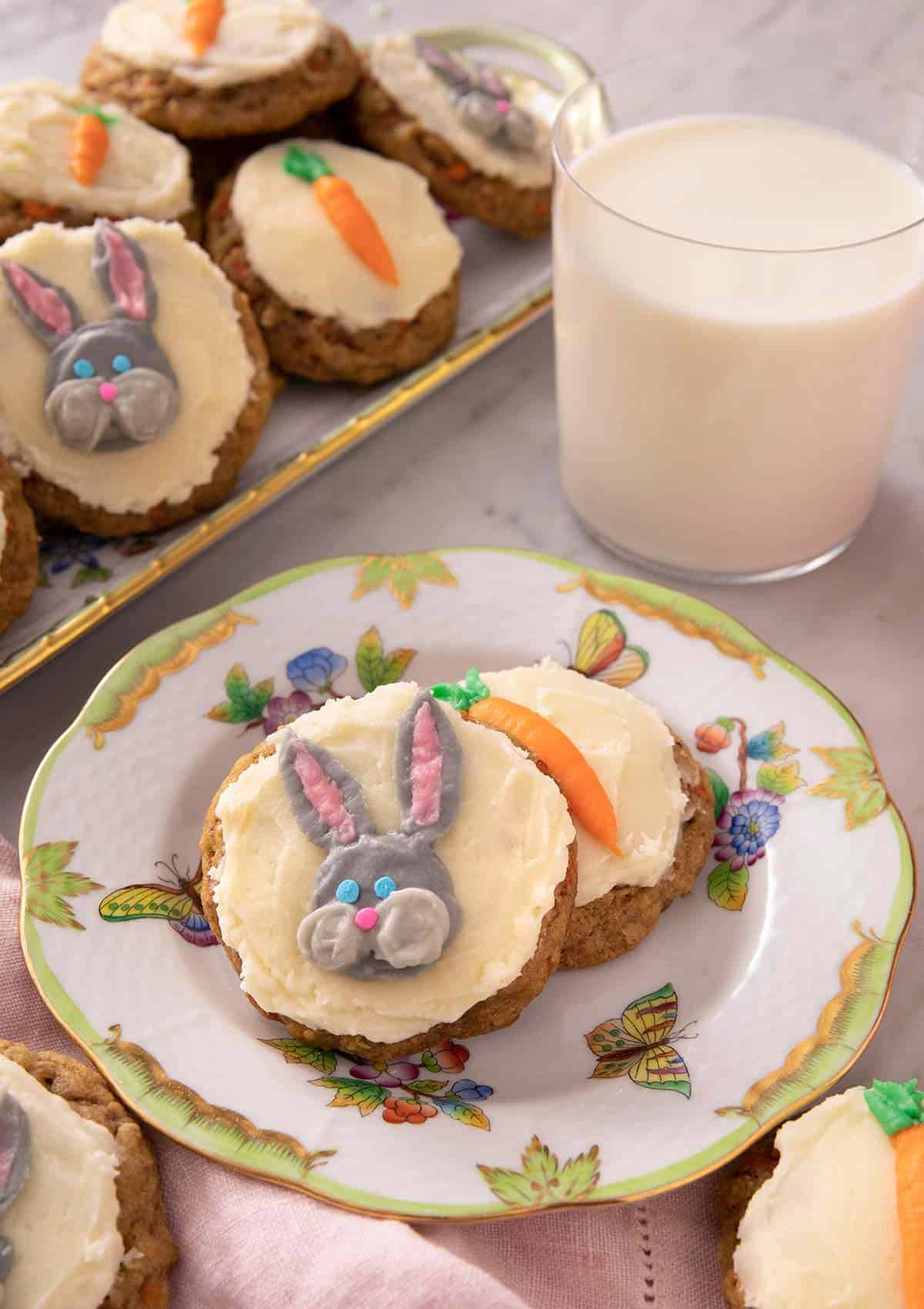 Carrot cake cookies on a plate with a glass of milk in the background