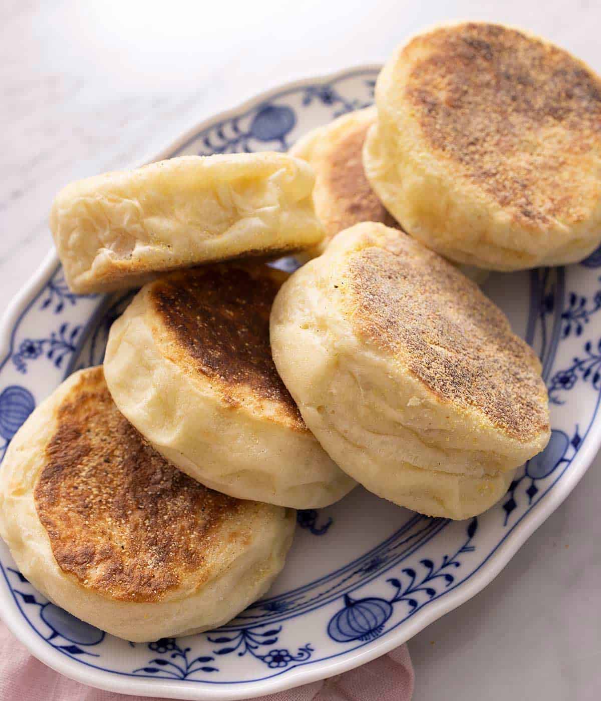 A pile of English Muffins on a blue serving plate