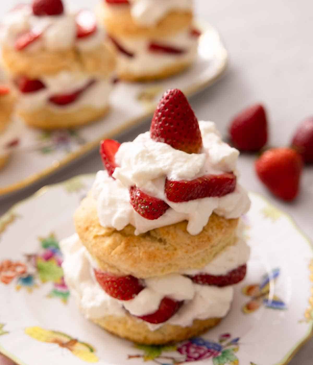 A strawberry short cake topped with whipped cream and strawberries.