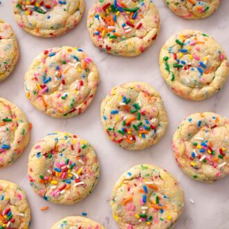 Pinterest graphic of a flatlay of multiple funfetti cookies with sprinkles strewn near the bottom.