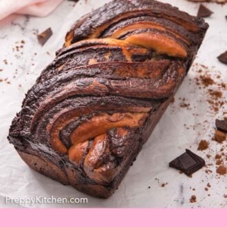 Pinterest graphic of a loaf of babka on a piece of parchment with roughly chopped chocolate around it.