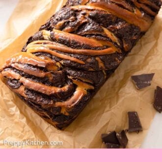 Pinterest graphic of an overhead view of a loaf of babka on a sheet of brown parchment with roughly chopped chocolate beside it.