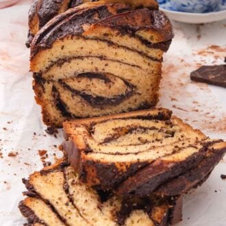 Pinterest graphic of a cut loaf of babka showing the interior, with two slices in front of it.
