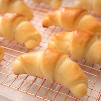 Pinterest graphic of crescent rolls on a rose gold cooling rack.