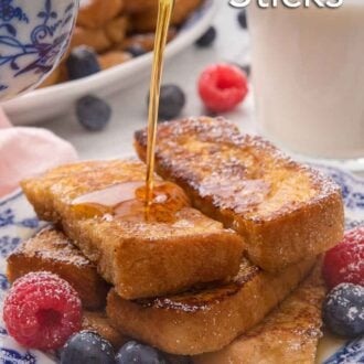 Pinterest graphic of maple syrup being poured onto a stack of French toast sticks with berries on the plate and a glass of milk in the background.