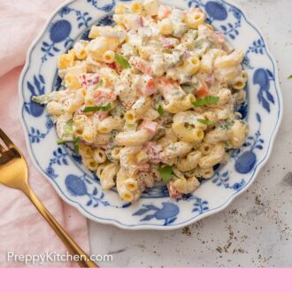 A Pinterest graphic of an overhead view of a plate of macaroni pasta salad beside a gold fork and pink napkin.
