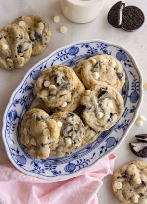 Overhead view of an oval platter of cookies and cream cookies with a couple scattered around it with oreos.