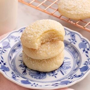 A stack of cream cheese cookies on a blue and white plate