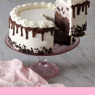 Pinterest graphic of an ice cream cake on a pink cake stand with a slice being lifted out.