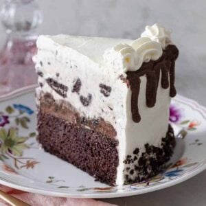 A slice of ice cream cake with Oreos on a floral plate.