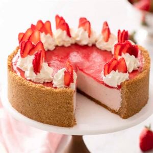 A no bake strawberry cheesecake with whipped cream dollops and strawberry slices on top.