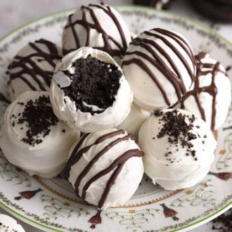 Oreo balls drizzled with chocolate on a plate.