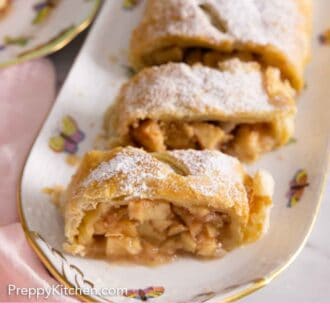 Pinterest graphic of a platter with cut apple strudel with powdered sugar on top.