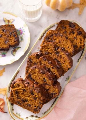 A serving platter with sliced chocolate chip pumpkin bread.