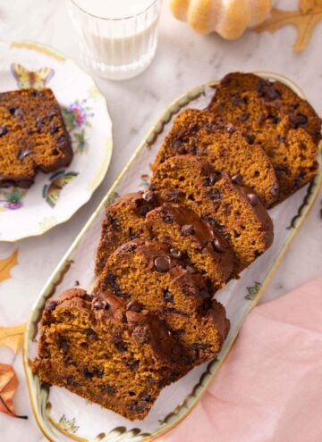 A serving platter with sliced chocolate chip pumpkin bread.