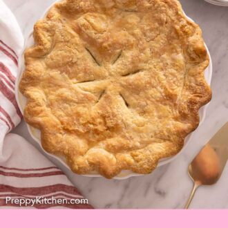 Pinterest graphic of an overhead view of a chicken pot pie with a gold colored pie server on the side.