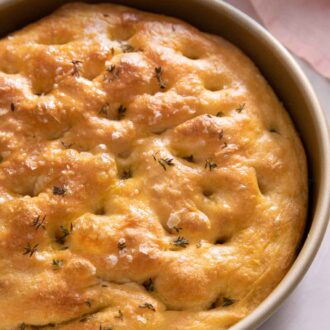 Pinterest graphic of a circular pan with focaccia inside.