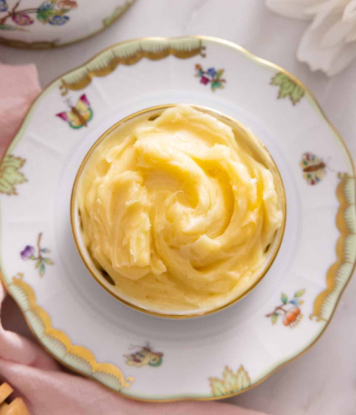 Overhead view of a bowl of honey butter on a plate.
