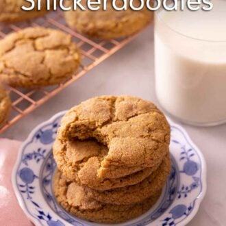 Pinterest graphic of a plate with stacked pumpkin snickerdoodles cookies beside a glass of milk and a cooling rack with more cookies.