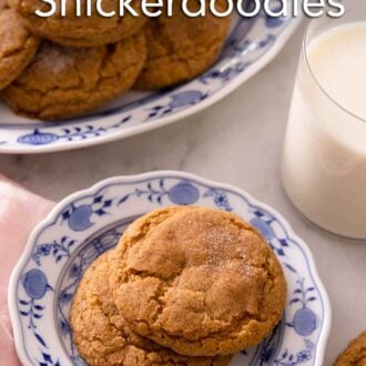 Pinterest graphic of a plate with two pumpkin snickerdoodles in front of a platter of cookies and a glass of milk.
