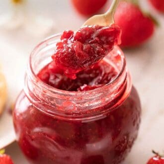 Pinterest graphic of a jar of strawberry jam with a spoonful lifted up.