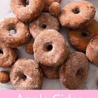 Pinterest graphic of a pile of apple cider donuts and donut holes on a counter.