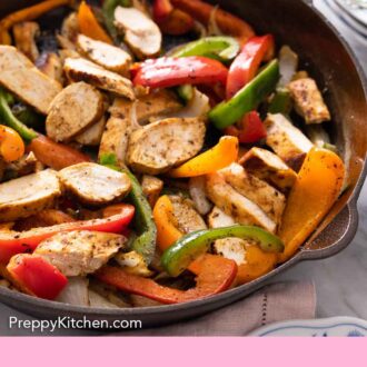 Pinterest graphic of a close up of a cast iron skillet containing chicken fajitas.