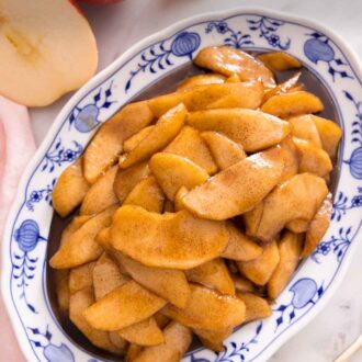 Pinterest graphic of an overhead view of an oval platter of fried apples with cut apples beside it.