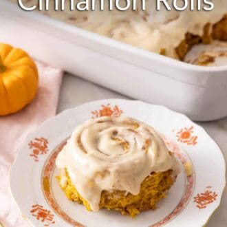 Pinterest graphic of a pumpkin cinnamon roll with cream cheese frosting in front of a baking dish with the rest.