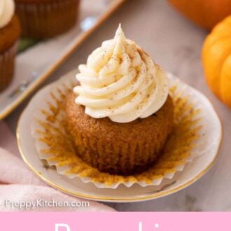 Pinterest graphic of a plate with a pumpkin cupcakes with cream cheese frosting on top.