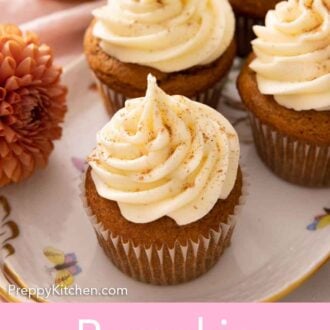 Pinterest graphic of an oval plate with multiple pumpkin cupcakes.