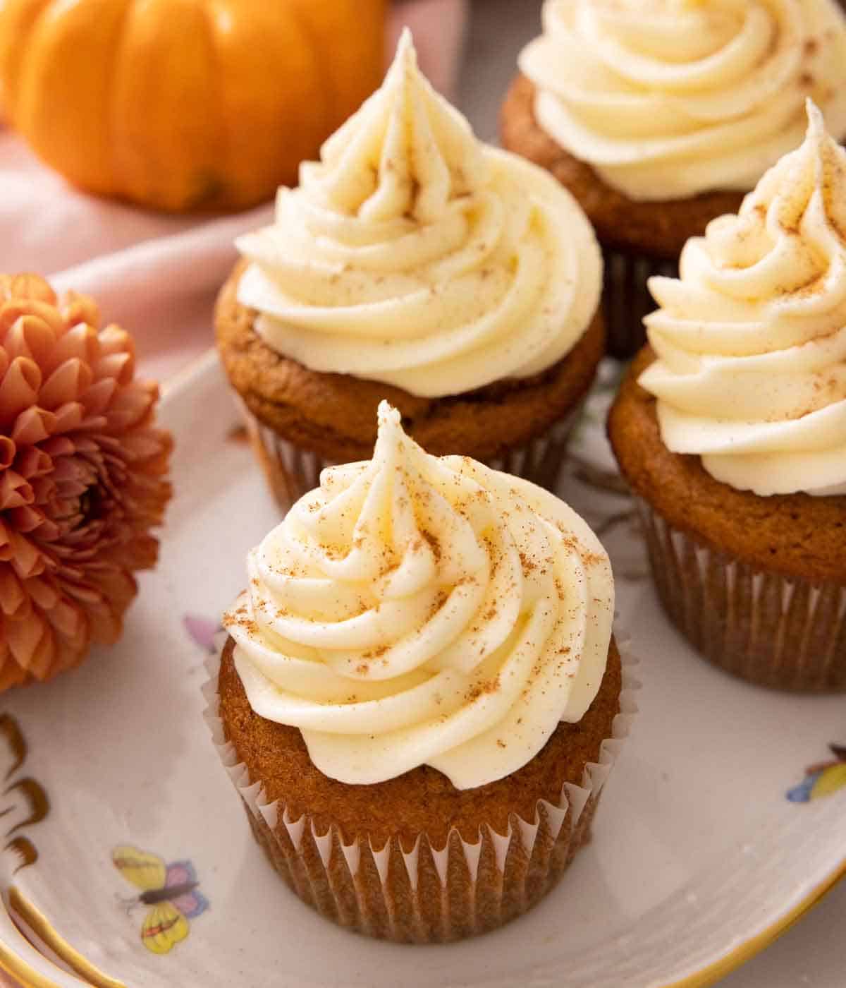 Multiple pumpkin cupcakes on an oval platter.