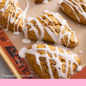 Pinterest graphic of multiple pumpkin scones on a lined sheet pan with glaze on top.