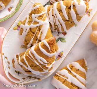 Pinterest graphic of the overhead view of multiple pumpkin scones on a platter with glaze drizzled over top.