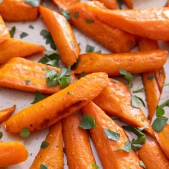A close up of a sheet pan of roasted carrots.