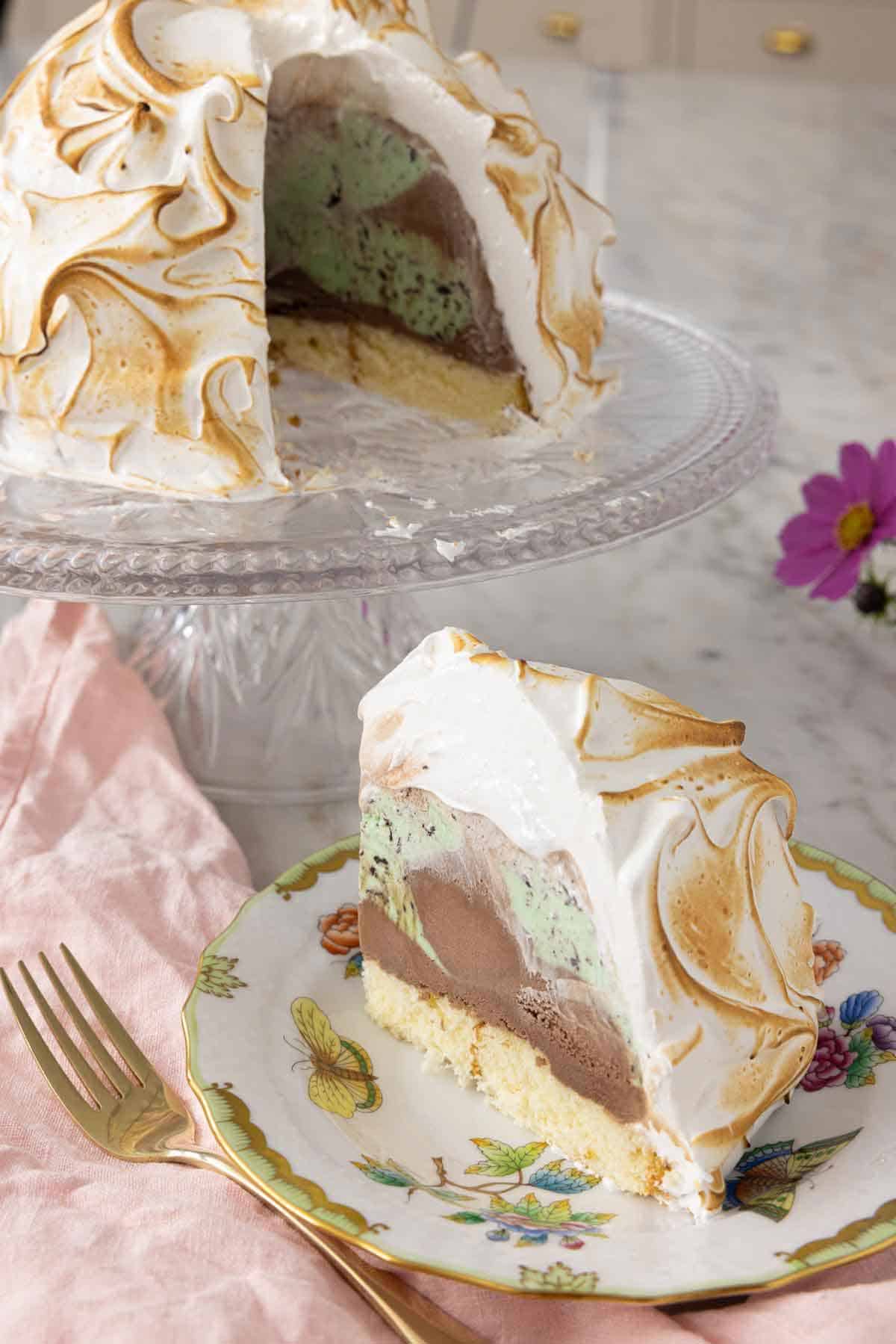 A plate with a slice of baked Alaska in front of the rest of the dessert.