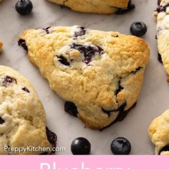 Pinterest graphic of blueberry scones with blueberries scattered on the counter.