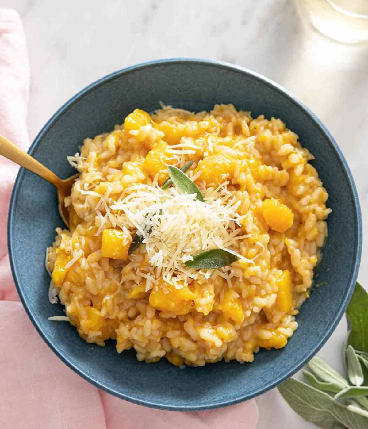 Overhead view of a bowl of butternut squash risotto with cheese on top.