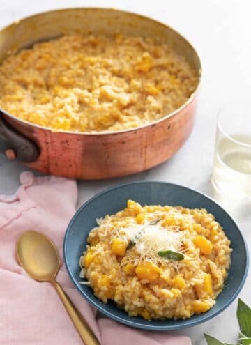 A bowl of butternut squash risotto in front of a pot with the rest.