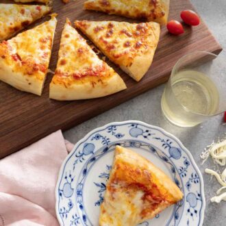 Pinterest graphic of a plate with a slice of cheese pizza in front of the rest of the pizza.