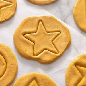Overhead view of dalgona candy with a star in the middle alongside other shapes like triangles and circles.