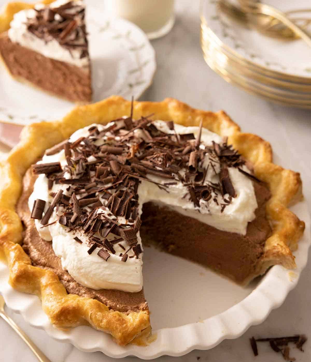 A pie dish containing French silk pie with a slice cut out.