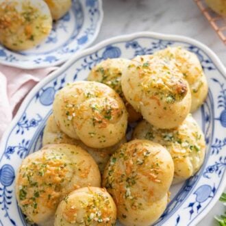 Pinterest graphic of a platter of garlic knots in front of a plate with two..