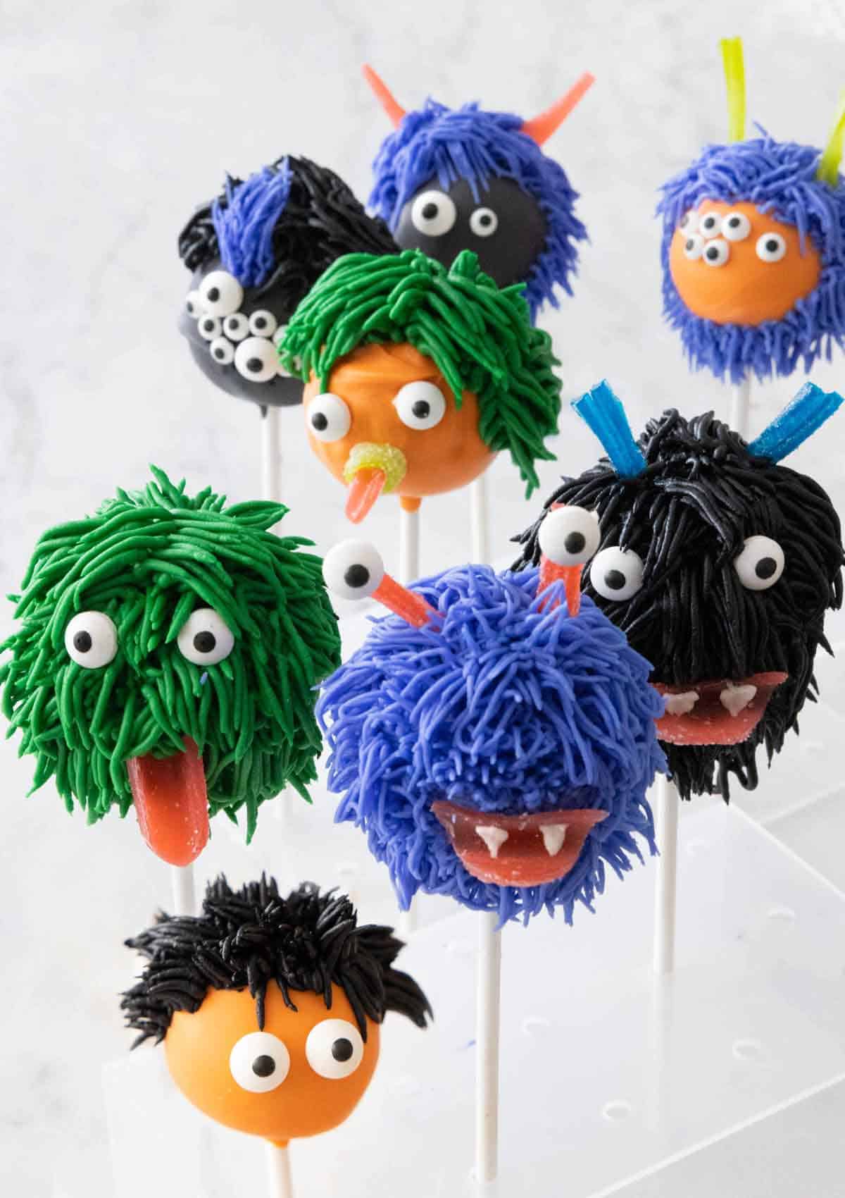 Eight Halloween cake pops decorated like monsters.