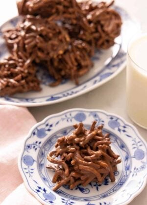 A haystack cookie on a plate with a platter behind it.