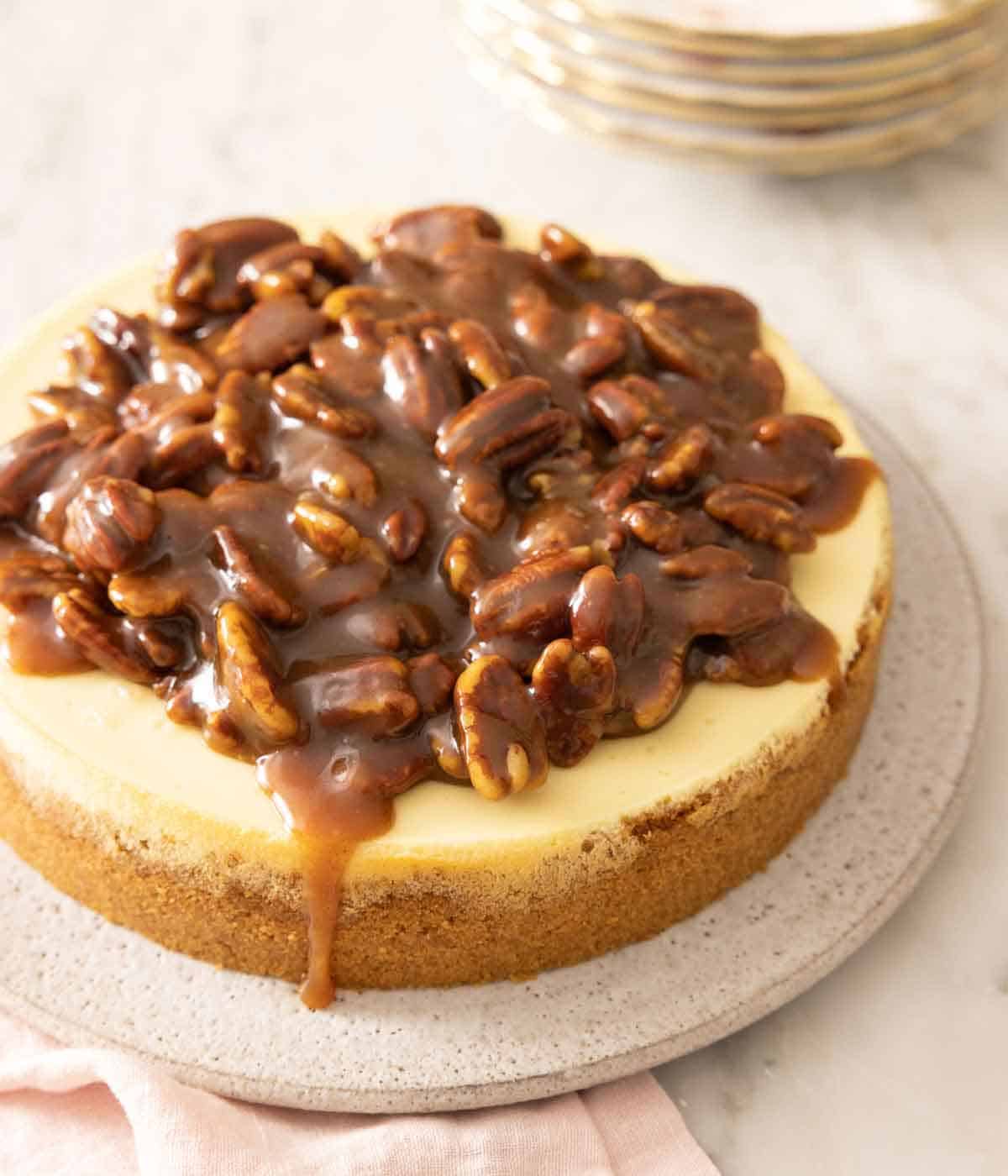 A pecan pie cheesecake on a serving platter.