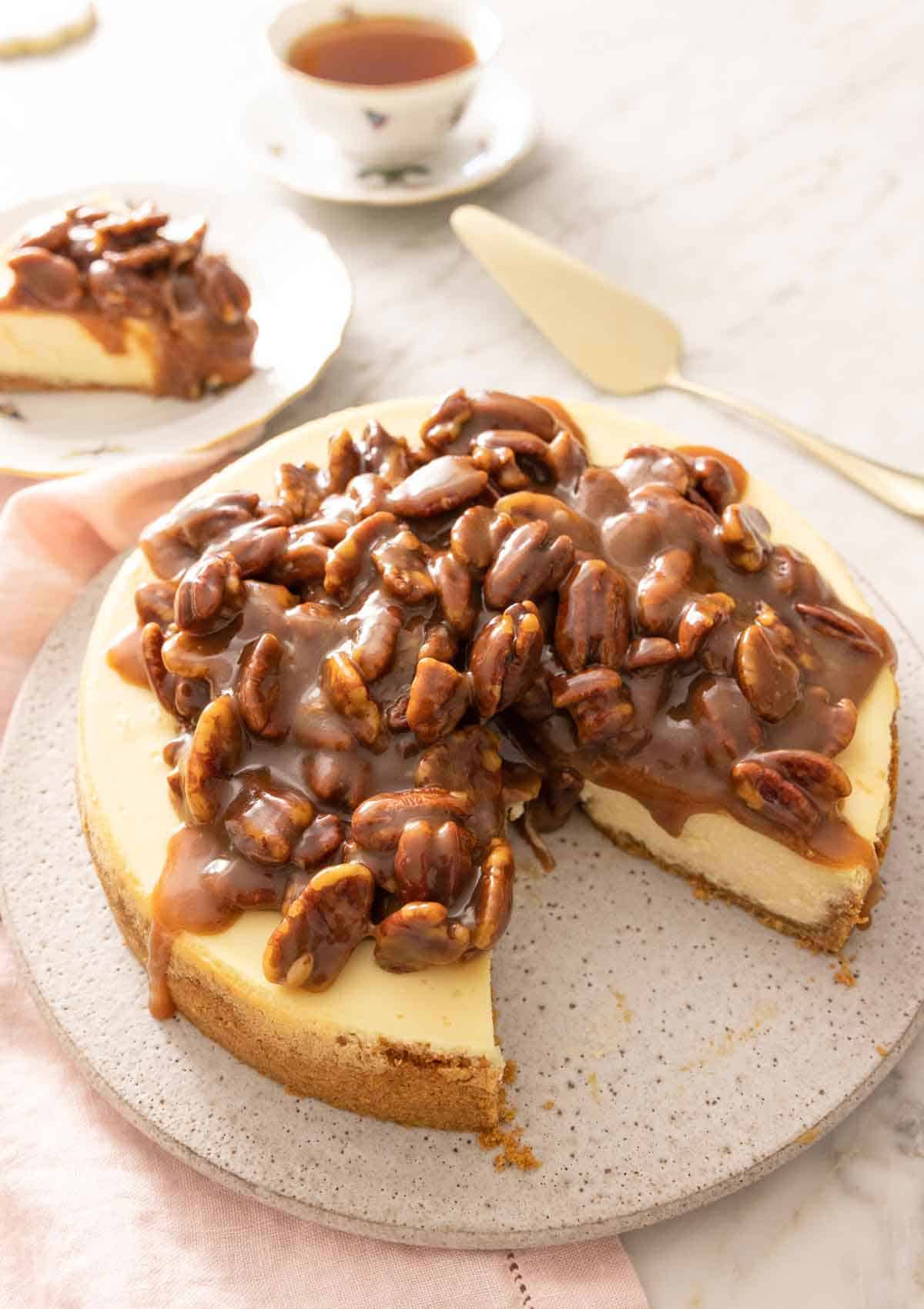 A pecan pie cheesecake with a slice taken out.