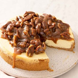 A pecan pie cheesecake with a slice cut out.