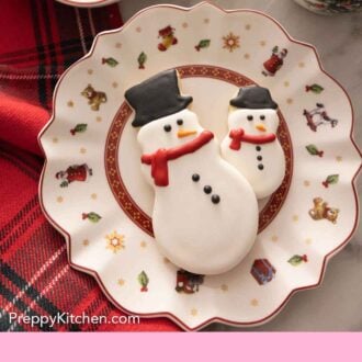 Pinterest graphic with two snowmen cookies decorated with royal icing.